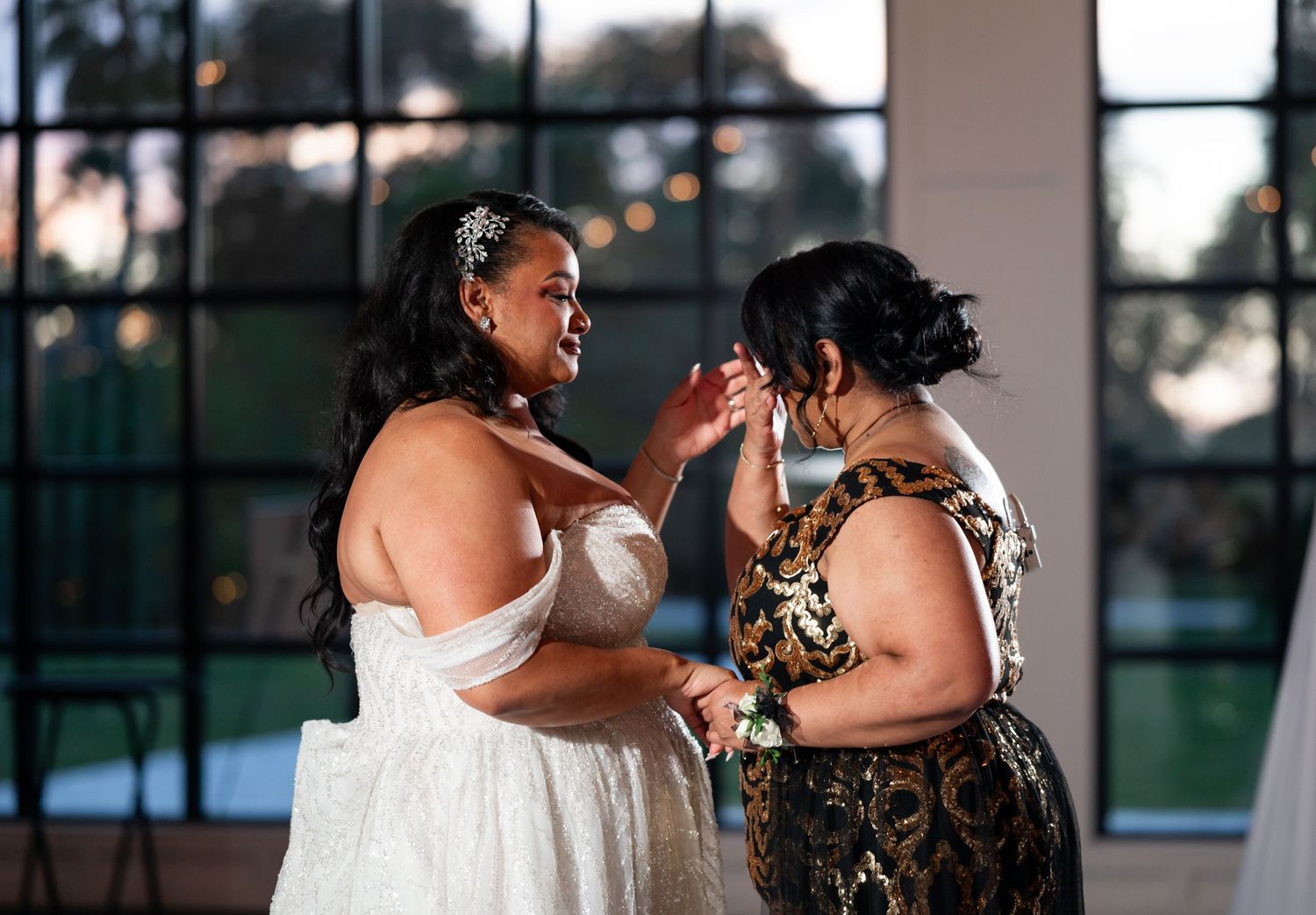 The mother dries her tears while dancing with her daughter during the mother-daughter dance at the reception.