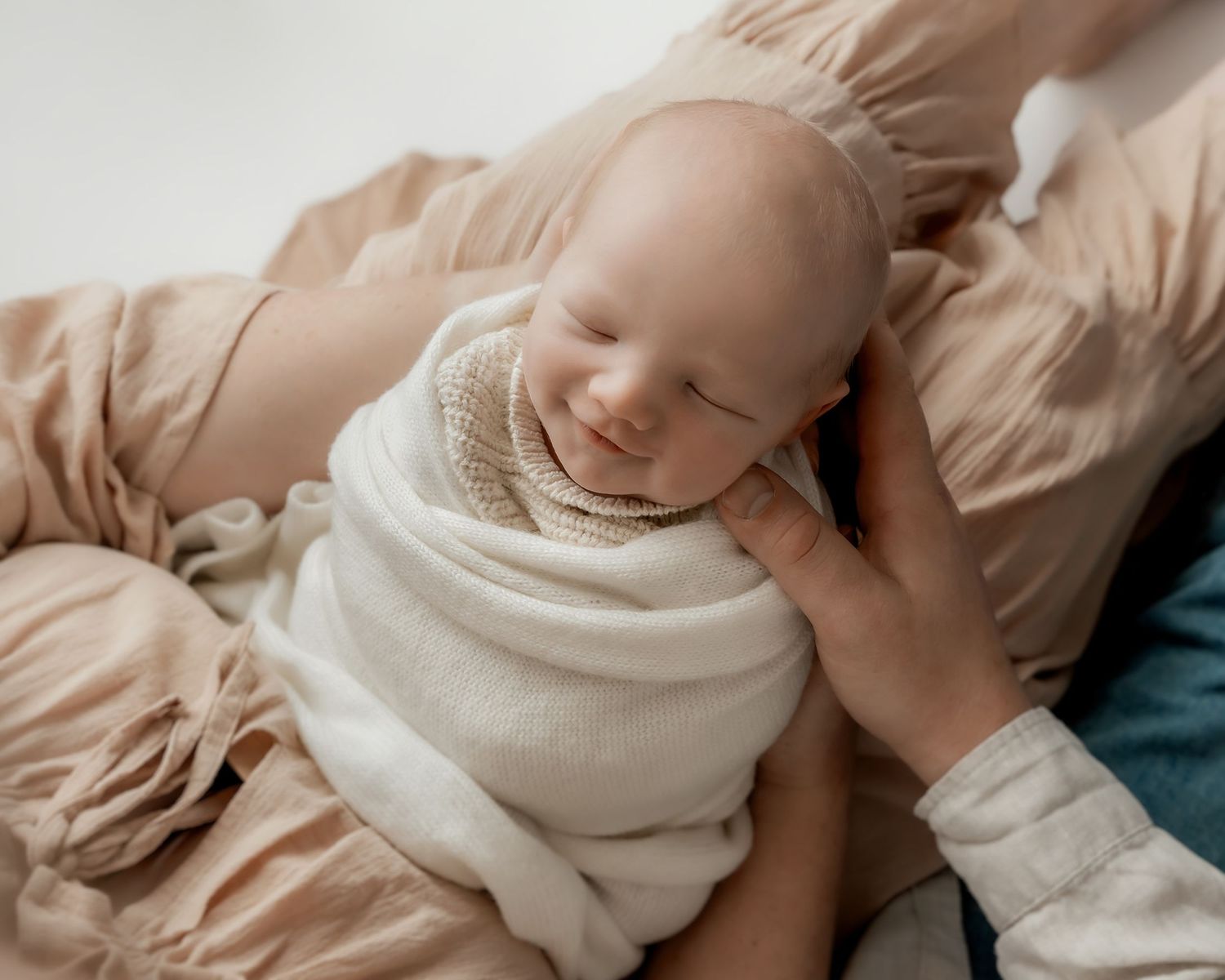 Newborn baby sleeping peacefully in parent's arms