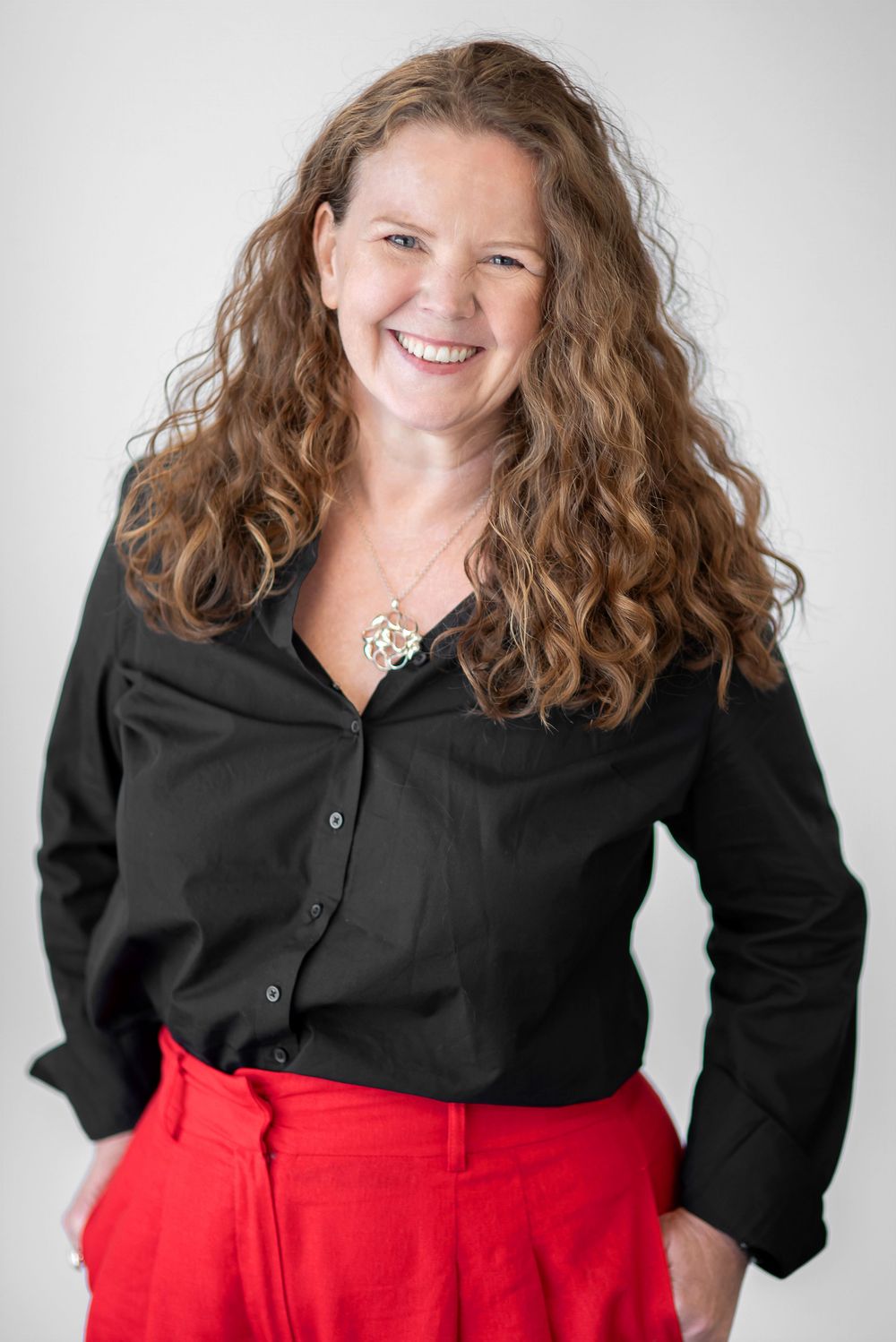 Professional portrait series showing a person in a black button-up shirt and red skirt against a white background.