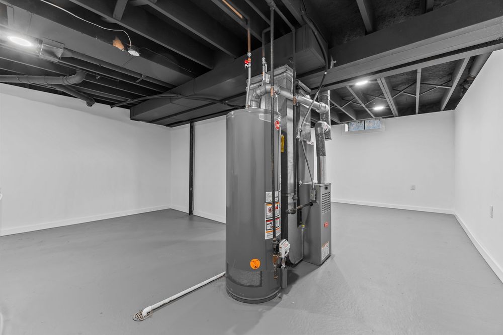 Basement mechanical room featuring a large water heater and HVAC system with exposed black ceiling joists.