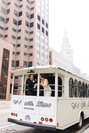 Bride and groom ride a white A-1 Mr. Limo wedding trolley through downtown Cleveland on their wedding day.