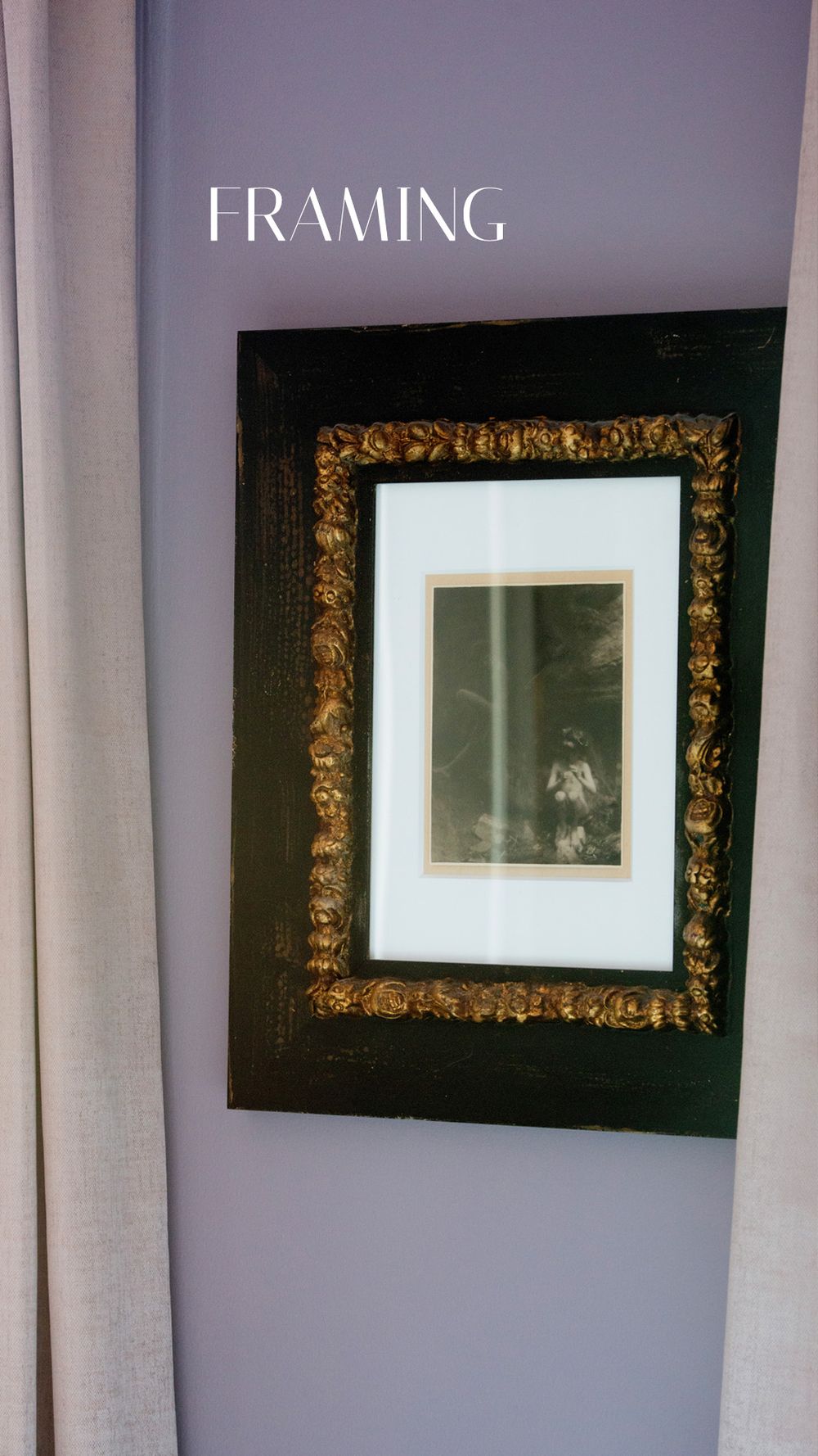 Ornate black and gold picture frame with matted vintage photograph displayed on a purple wall beside neutral curtains.