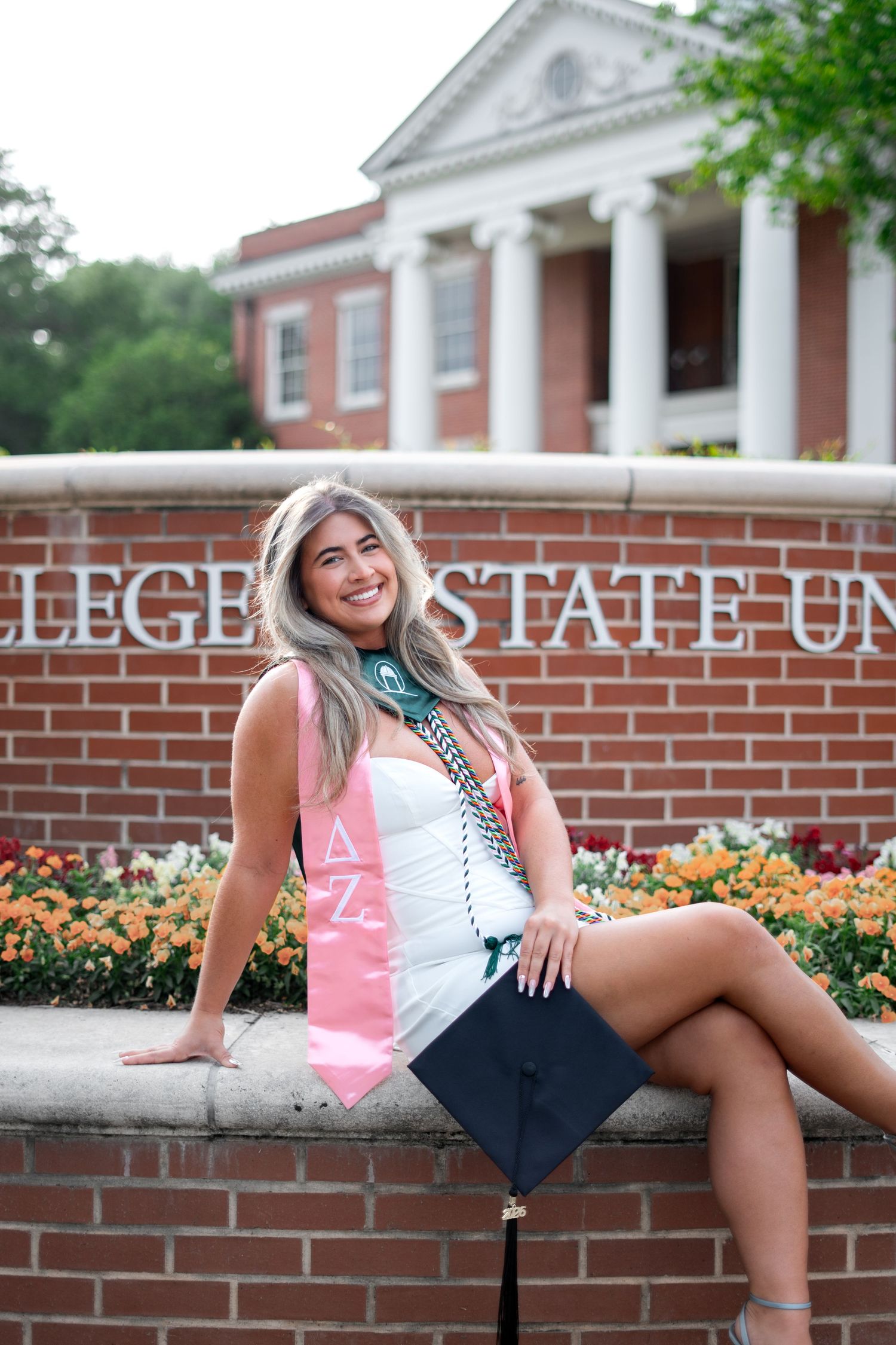 Graduate poses for best Milledgeville grad photos at Georgia College & State University GCSU with portraits by Pierre the Pear Photography