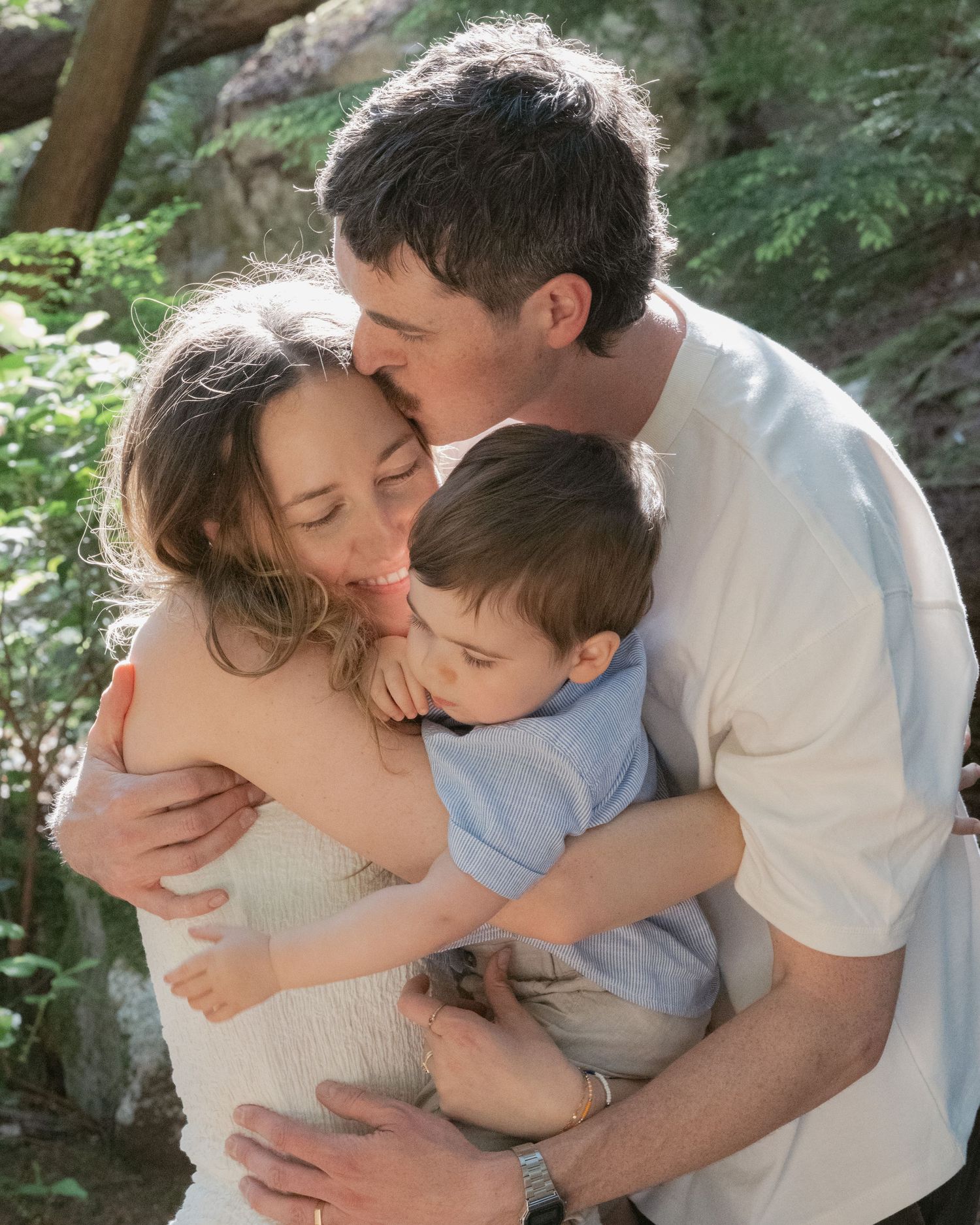 Parents embracing with toddler in golden forest light | Family portrait, Lighthouse Park, West Vancouver | Tash Takes Pics