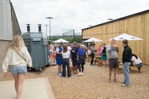 Attendees at the Chiltern Padel launch party stand around a building, photographed by Abigail's studio.