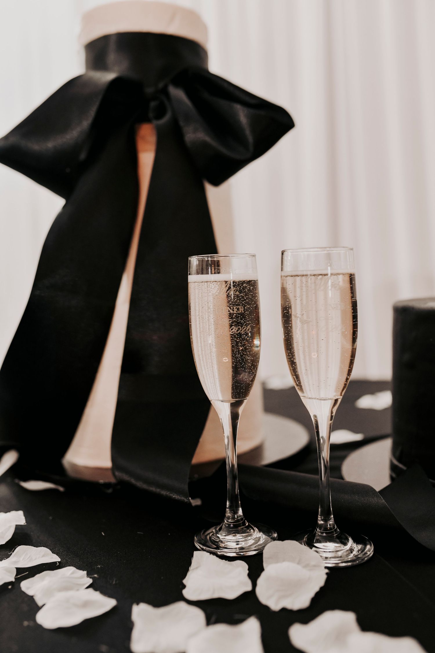 Modern wedding cake decorated with a dramatic black bow