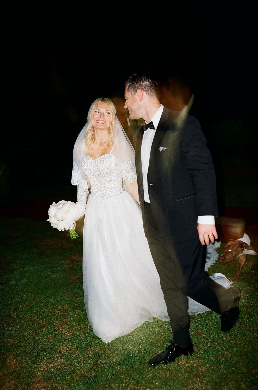A candid documentary photo of a bride and groom with night flash