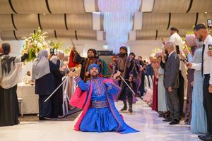 Wedding celebration featuring traditional folk dancers in colorful costumes performing for guests.