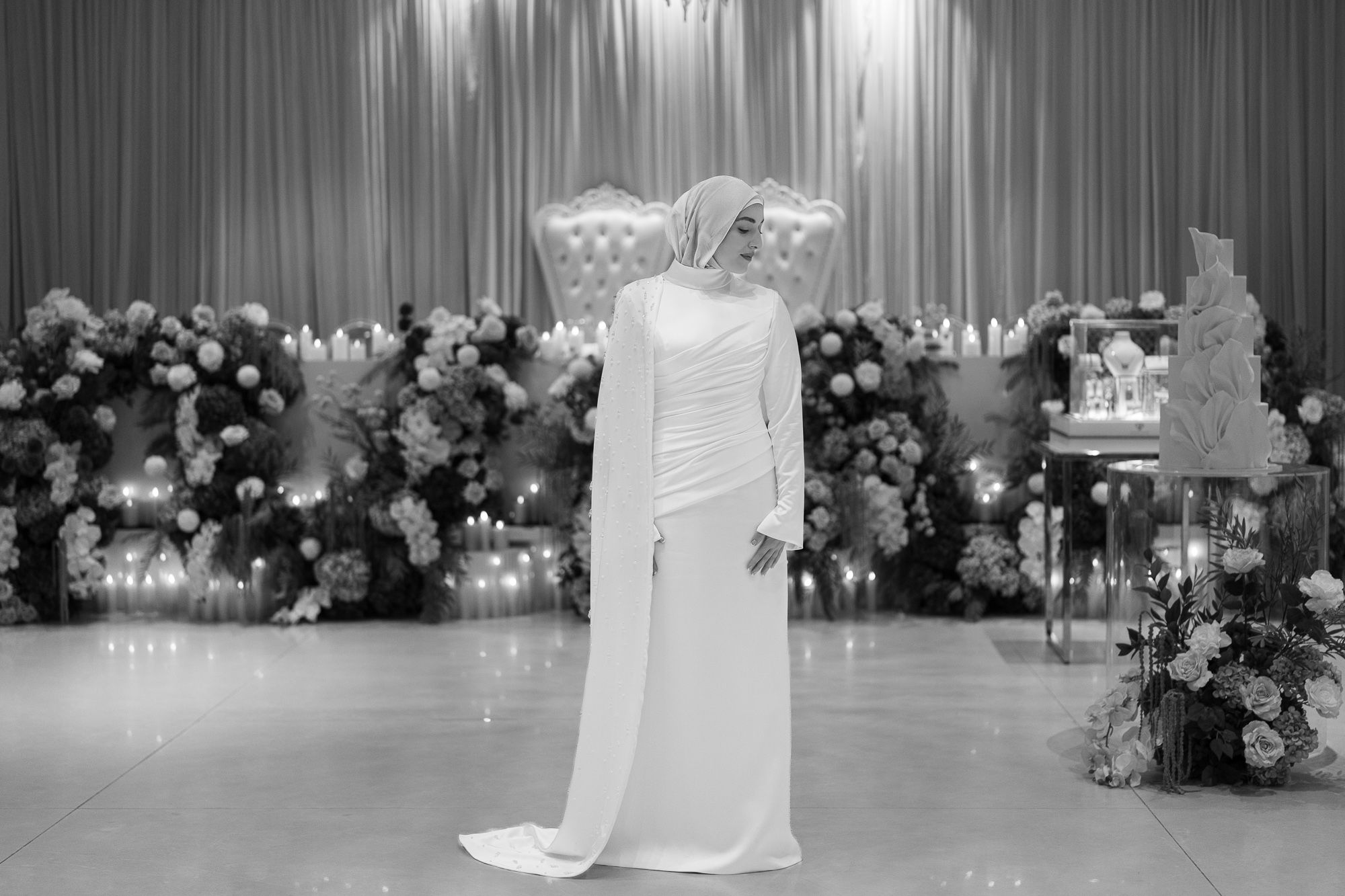 Elegant wedding reception venue with white draping and crystal chandeliers creating a romantic atmosphere.