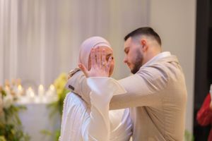 Intimate moment captured during a wedding celebration with soft lighting and floral decorations.