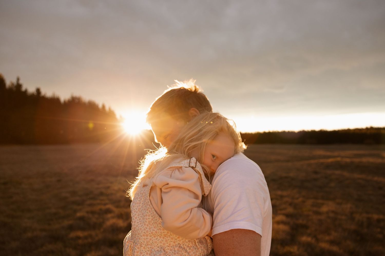 Dad and daughter cuddling at sunset session at mcleans island in christchurch