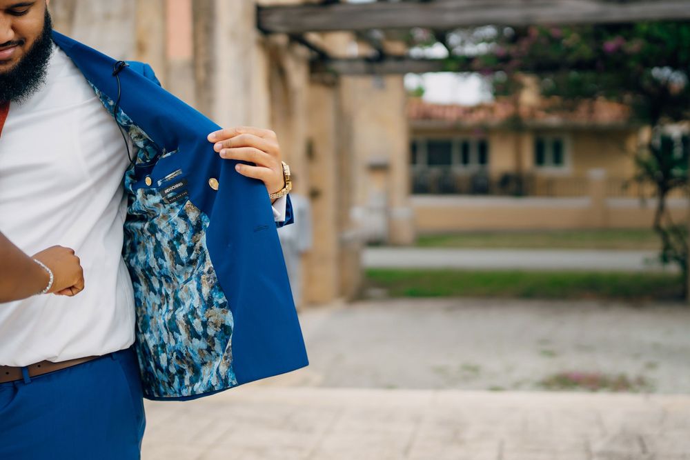 Close-up view of a blue suit jacket with decorative floral lining being displayed outdoors.