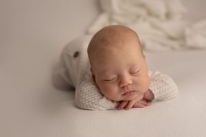 Artistic newborn photography series on neutral beige background showing peaceful sleeping poses.