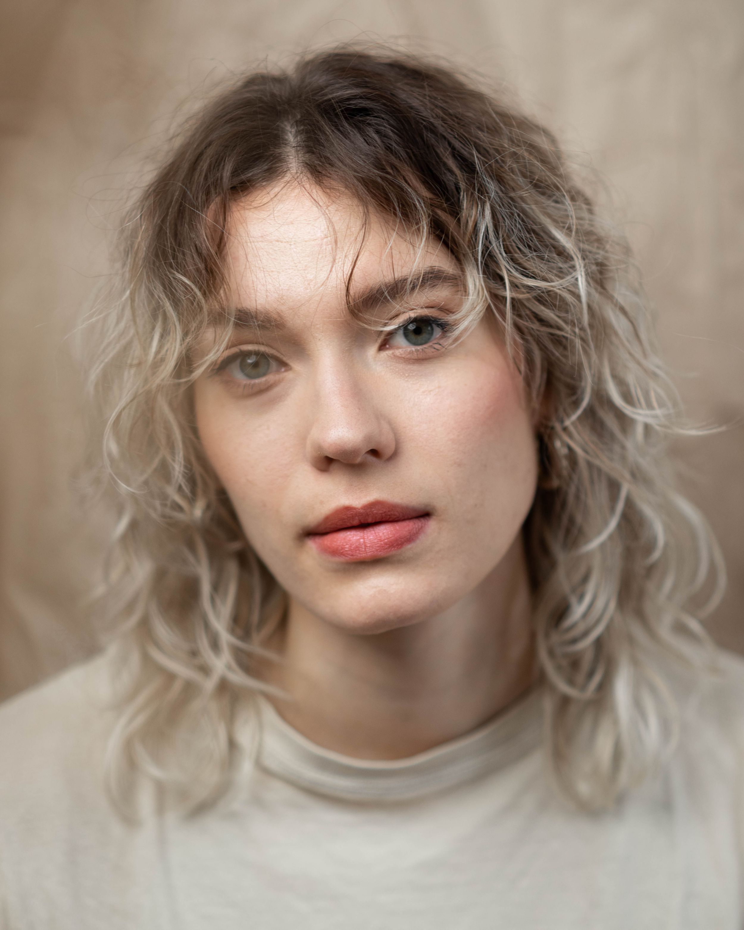 Portrait series showing soft lighting and neutral tones with changing expressions.