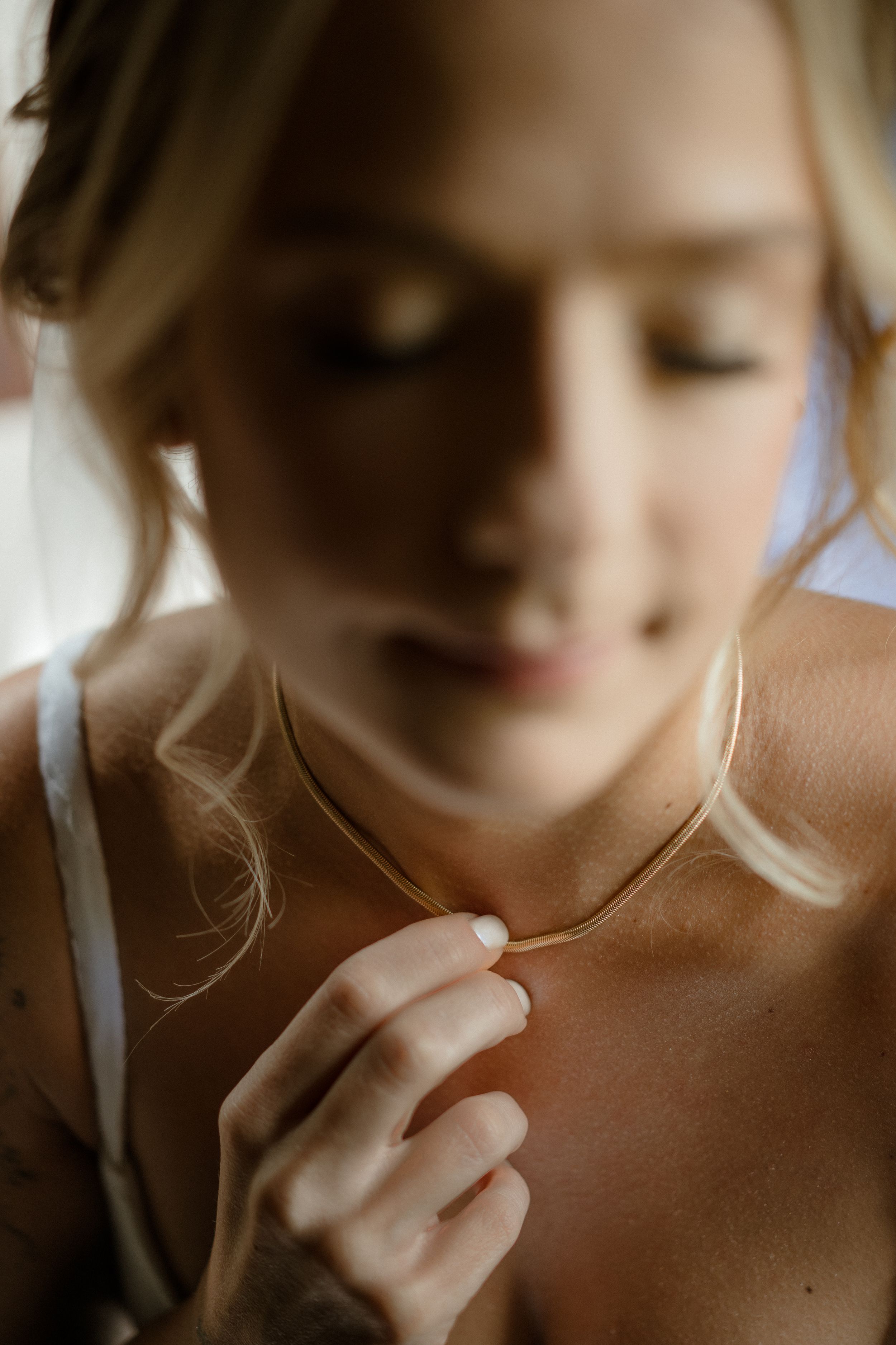 Intimate close-up shot with soft focus capturing gentle hand placement and natural lighting.