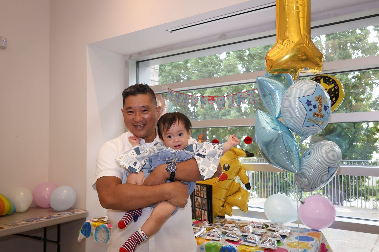 Man and little boy posing in front of balloons