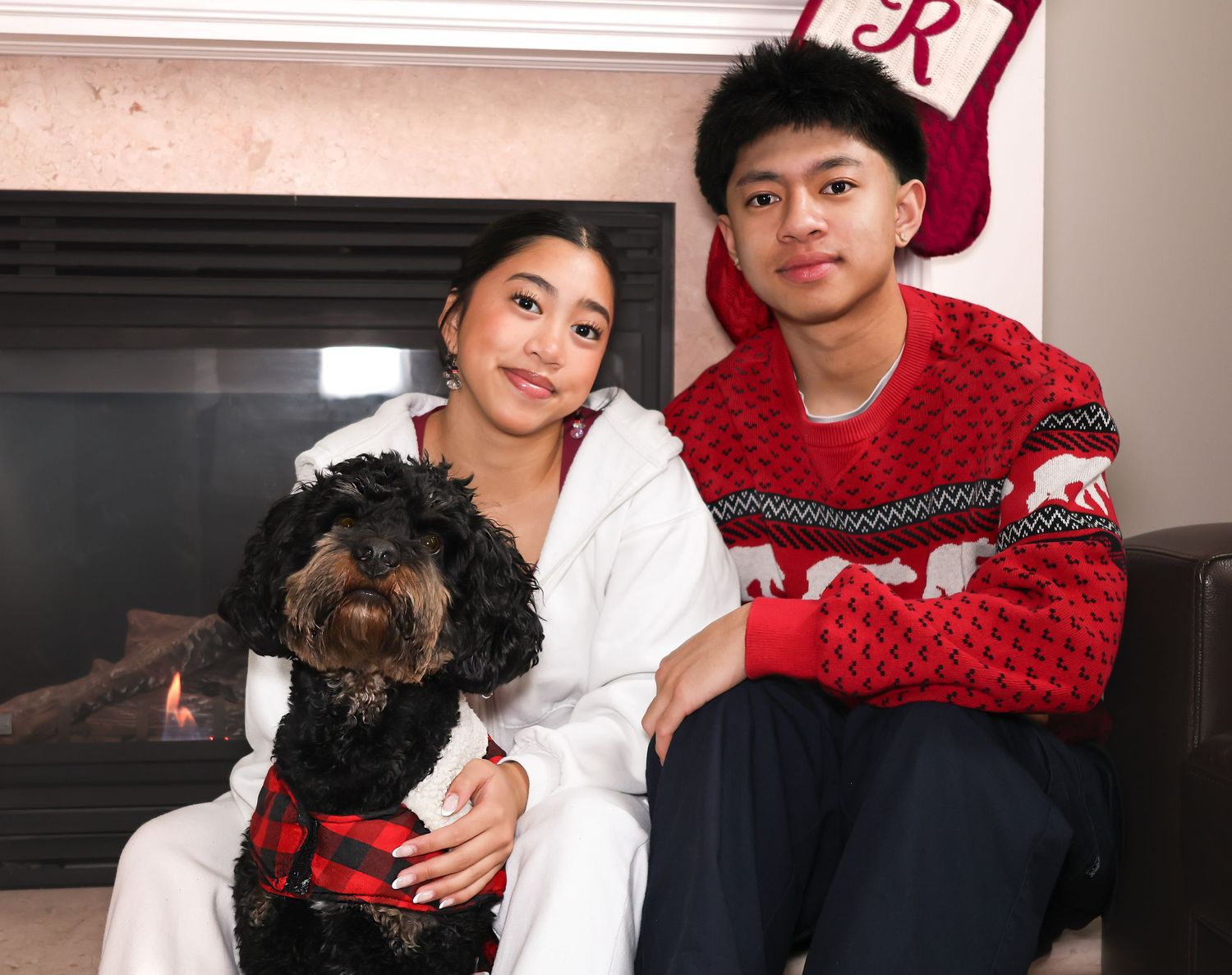 Two siblings sitting together with their family dog