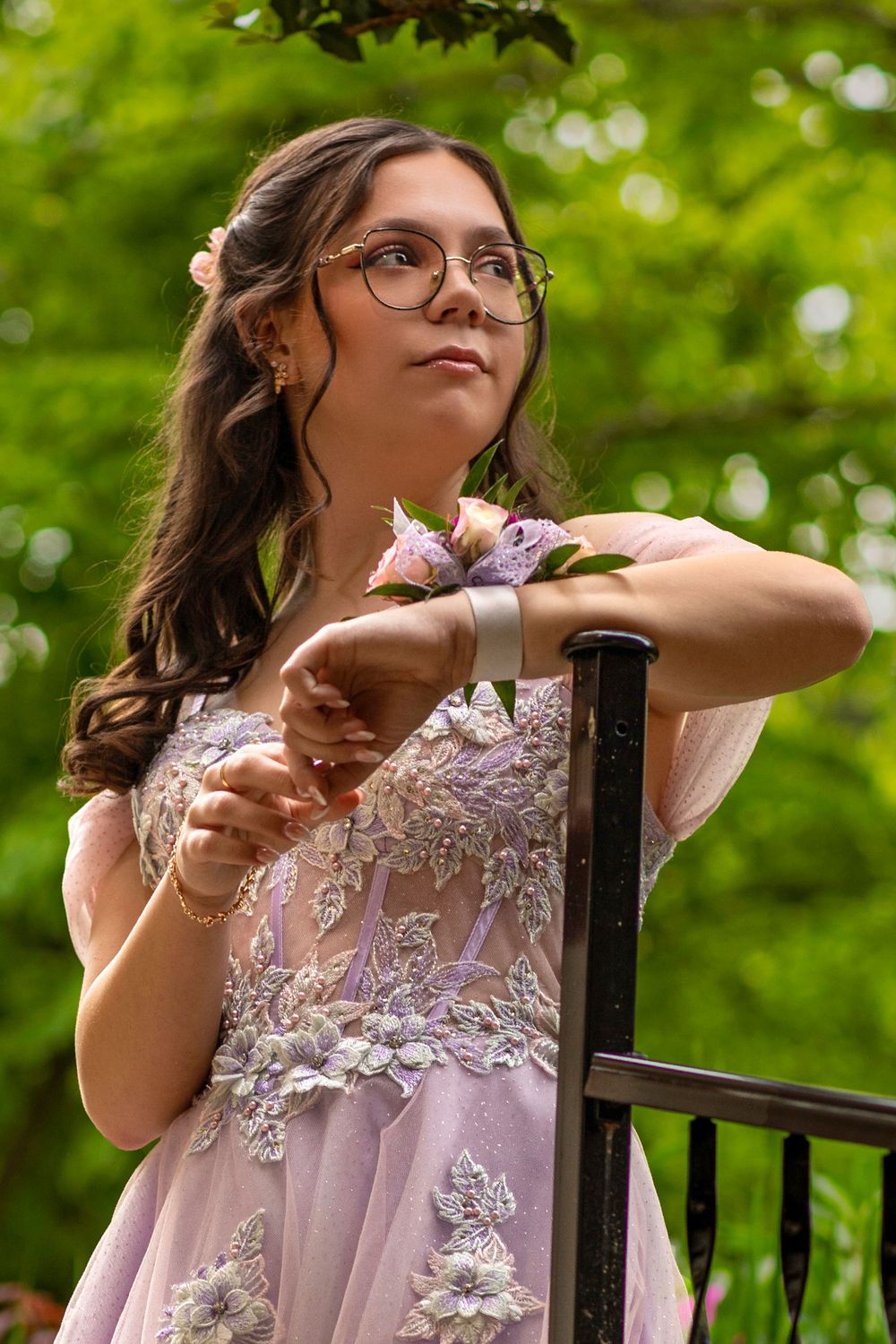 Elegant lavender gown with detailed lace embellishments and a corsage captured in a dreamy garden setting.