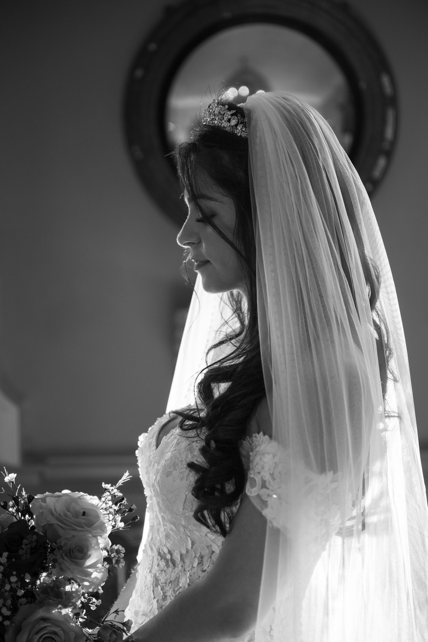 Black and white side profile portraits of a bride in a wedding veil and gown create an elegant bridal series.