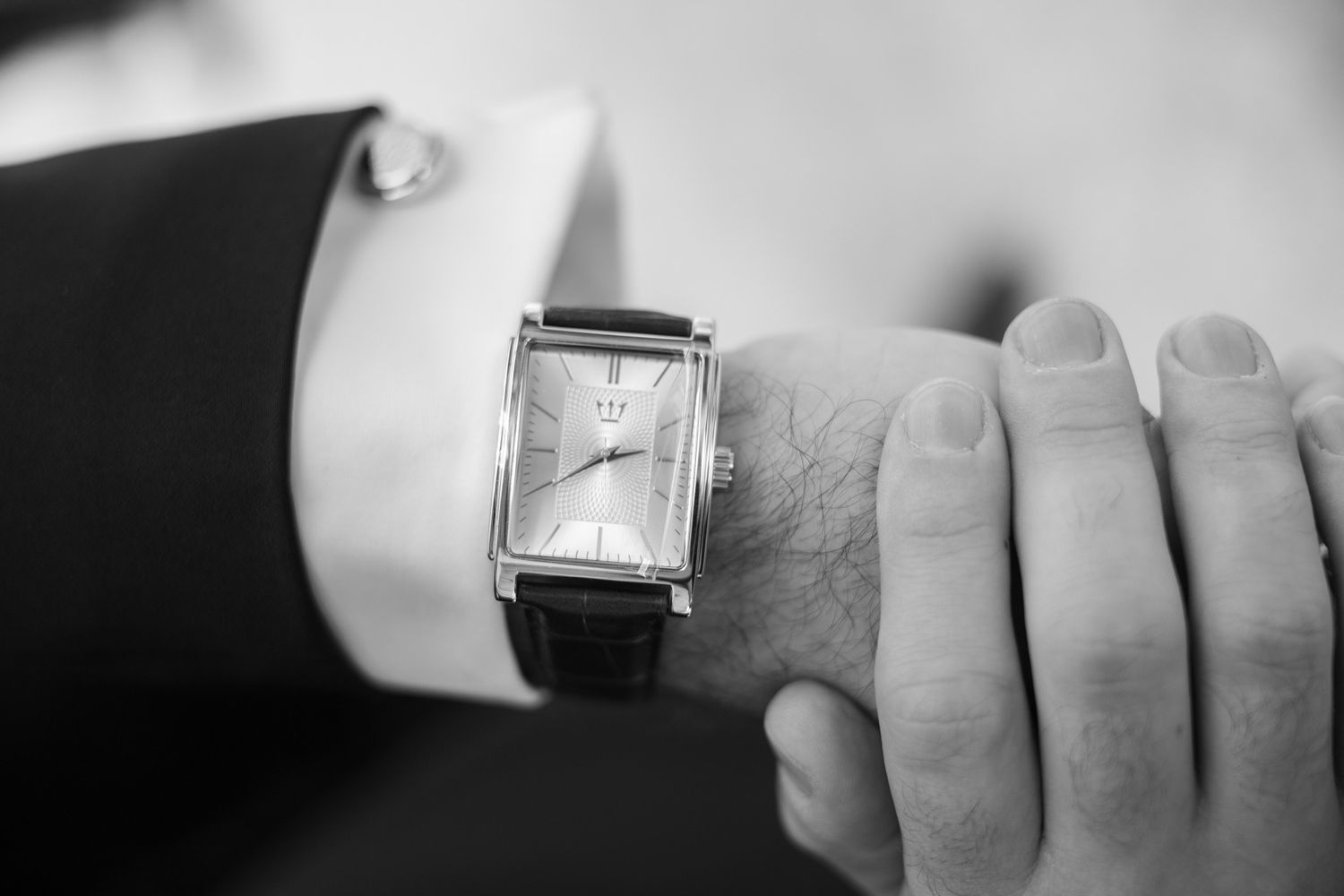 A black and white photo sequence showing a hand wearing a watch and ring against a light background.