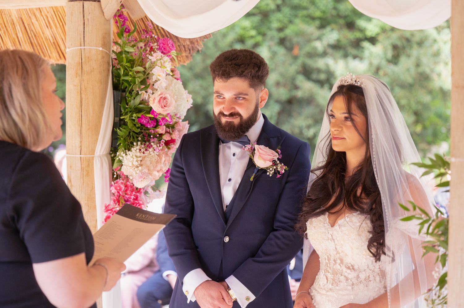 Elegant wedding couple shares a tender moment during their outdoor garden ceremony celebration.