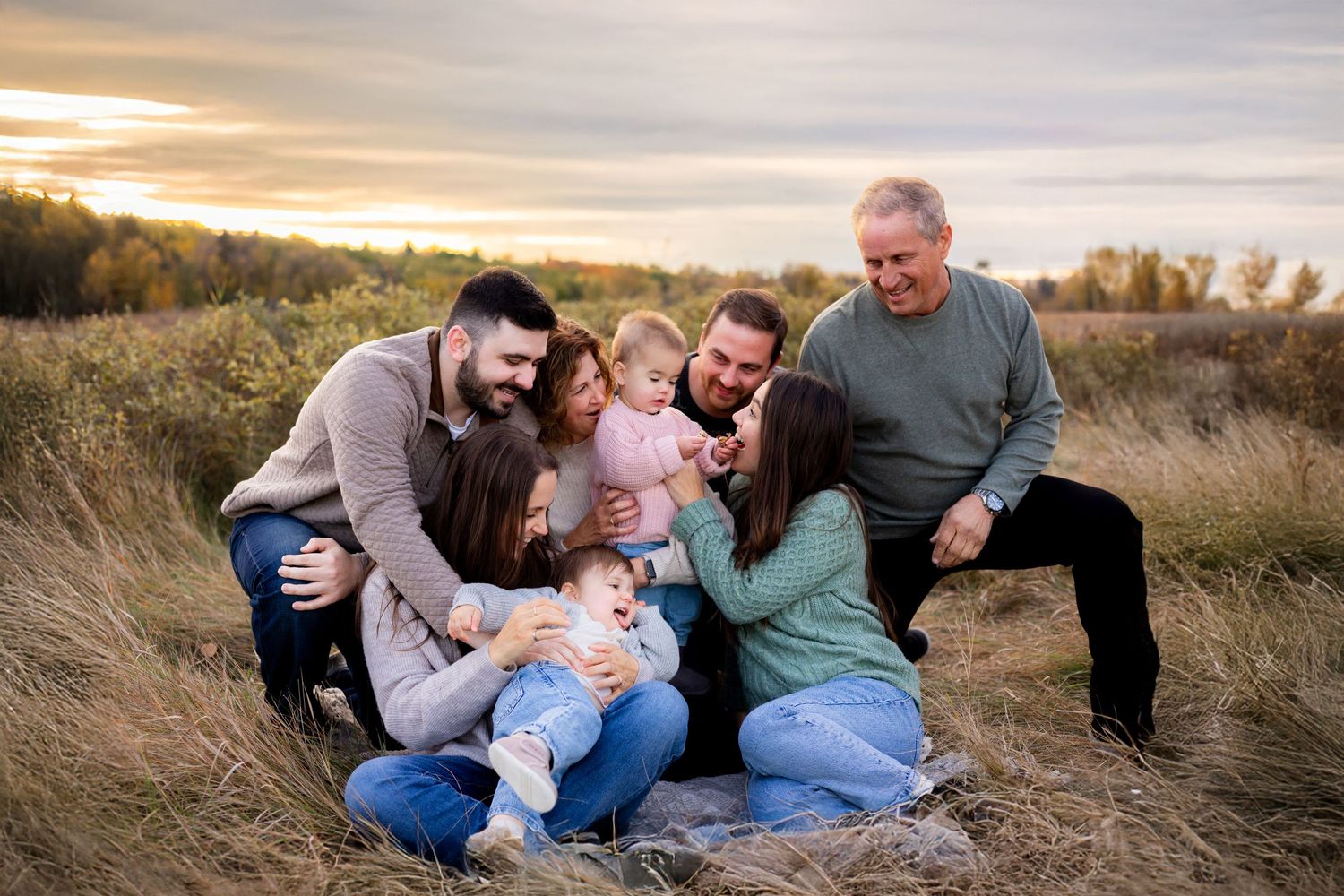 Large family cuddled together at a Calgary park during an extended family session based in Calgary, Alberta.