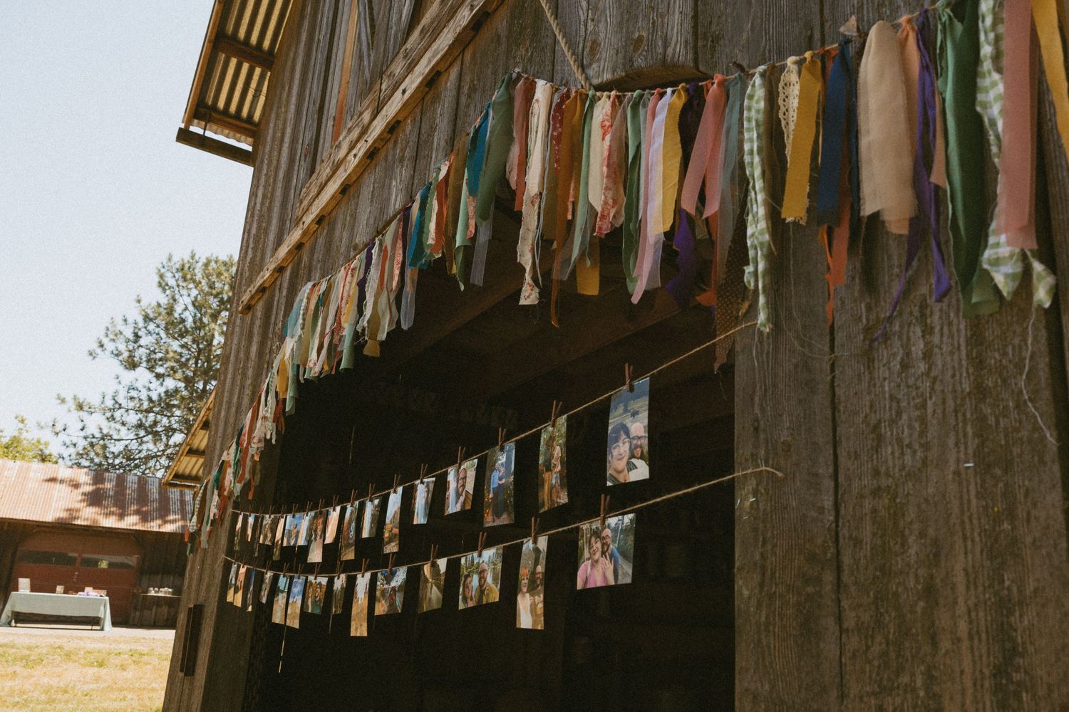 Colorful fabric banners hang decoratively from a rustic wooden barn structure.