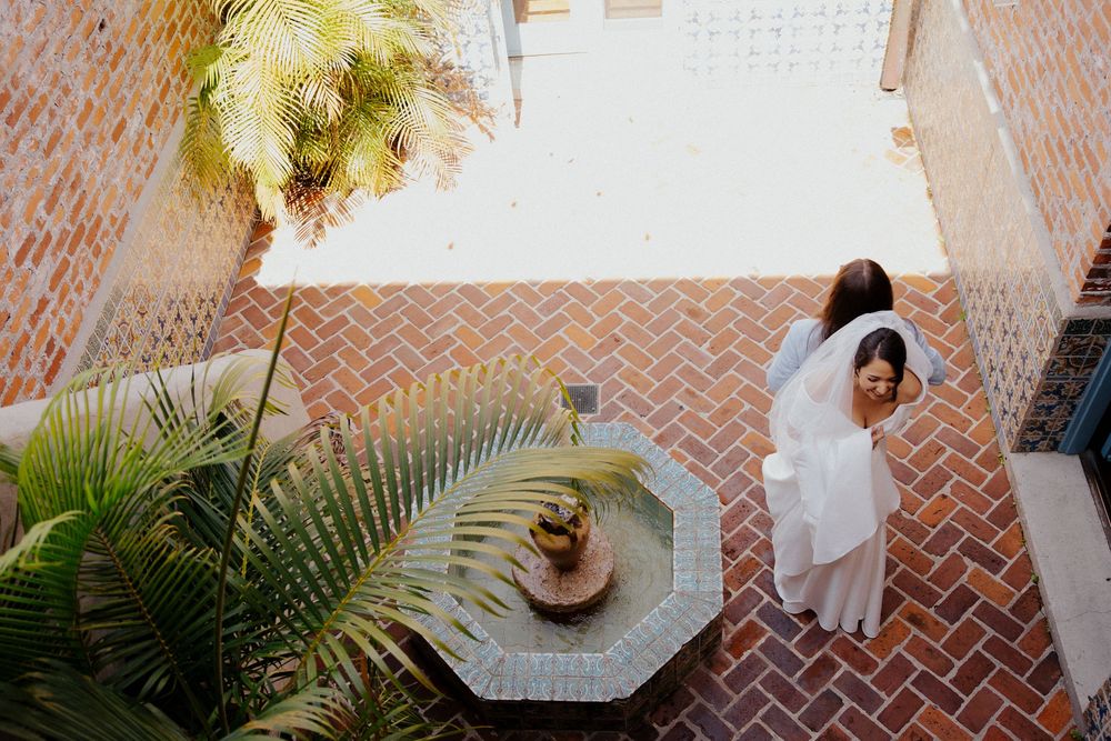 Aerial view of a courtyard with herringbone brick pattern, tropical plants and a small table with refreshments.