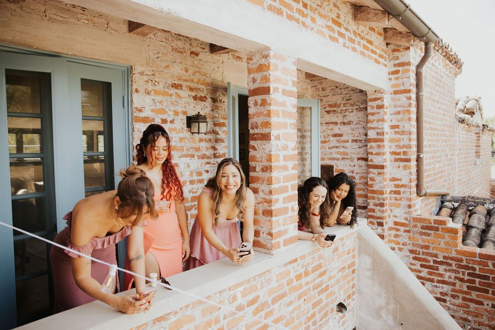 A series of wedding party photos taken against a rustic brick wall showing candid moments and preparations.