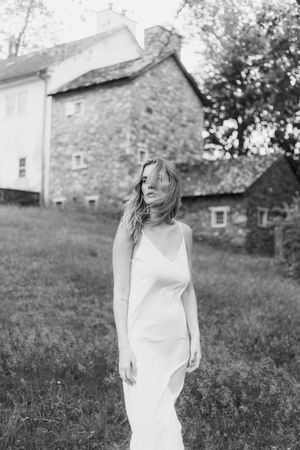 A black and white artistic portrait series captured against the backdrop of a rustic stone farmhouse.