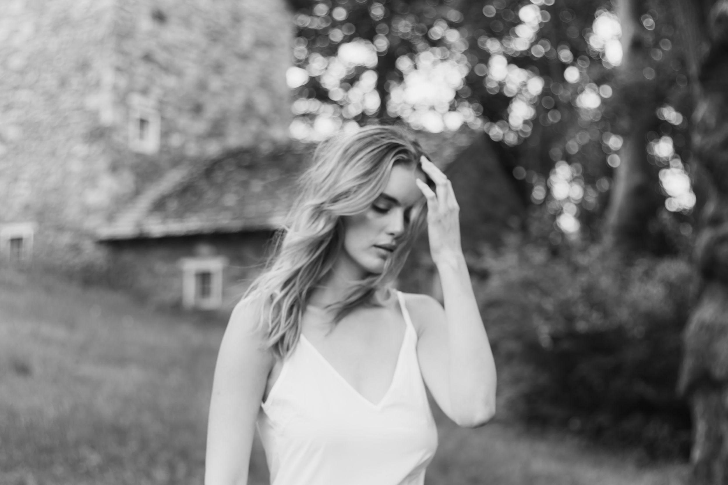 Black and white artistic portrait series showing elegant poses against natural outdoor backdrop.