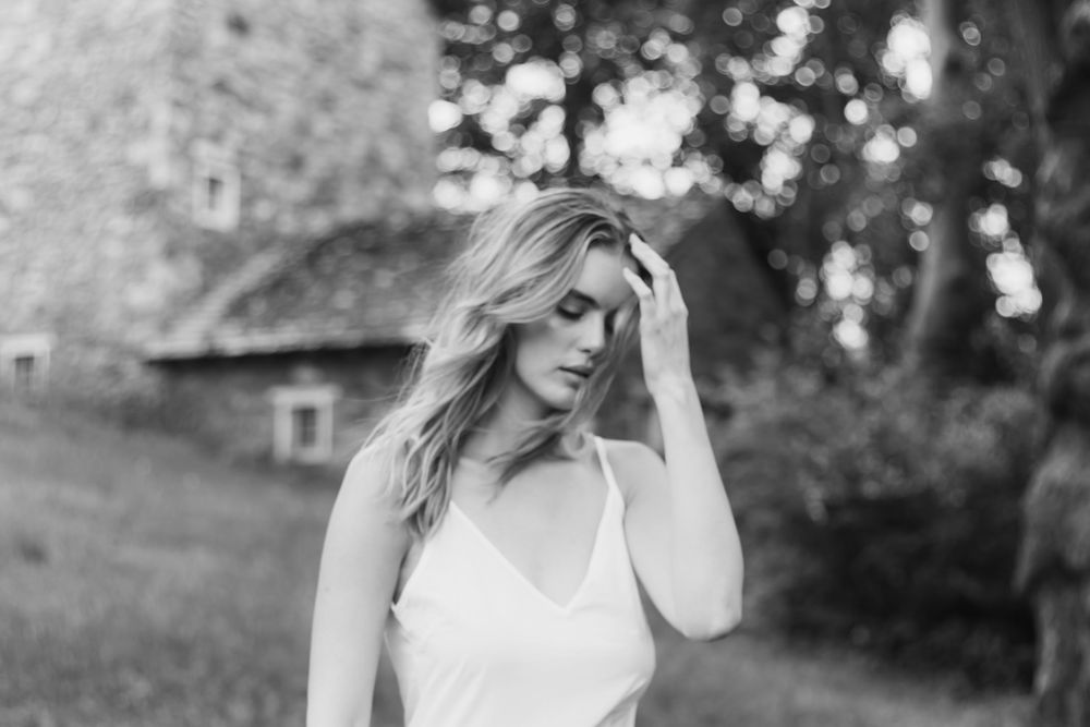 Black and white artistic portrait series showing elegant poses against natural outdoor backdrop.