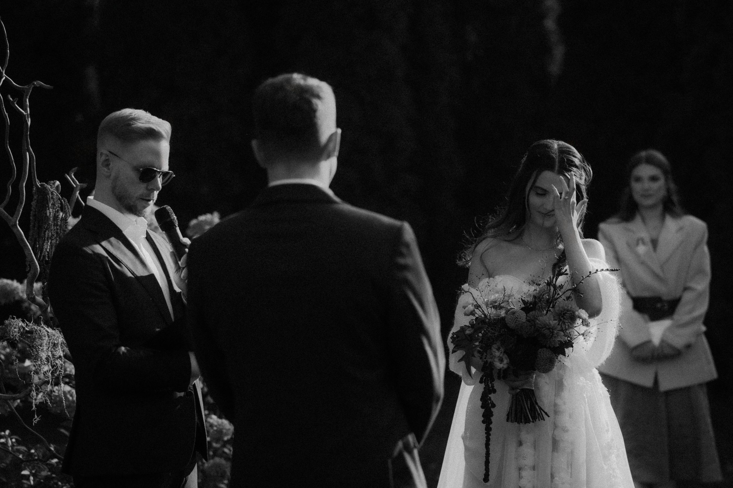 A black and white collage of wedding moments showing couples embracing and celebrating during a ceremony.