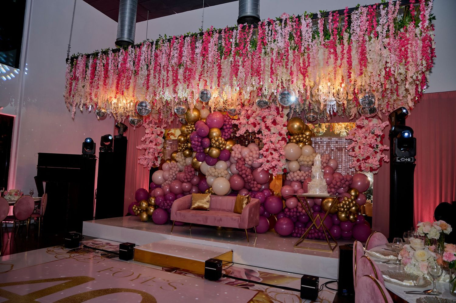 Pink floral ceiling installation creates a romantic ambiance in an event space.