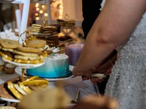 A collection of wedding reception tables with plates of food and drinks arranged in a festive setting.