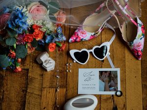 Wedding details including floral arrangements, signage, and decor displayed on rustic wooden walls at a reception venue.