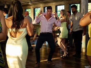 A group of people dance together in a bright indoor venue during what appears to be a social dance event or class.