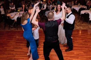 Couples dancing together on a wooden dance floor at an evening reception event.
