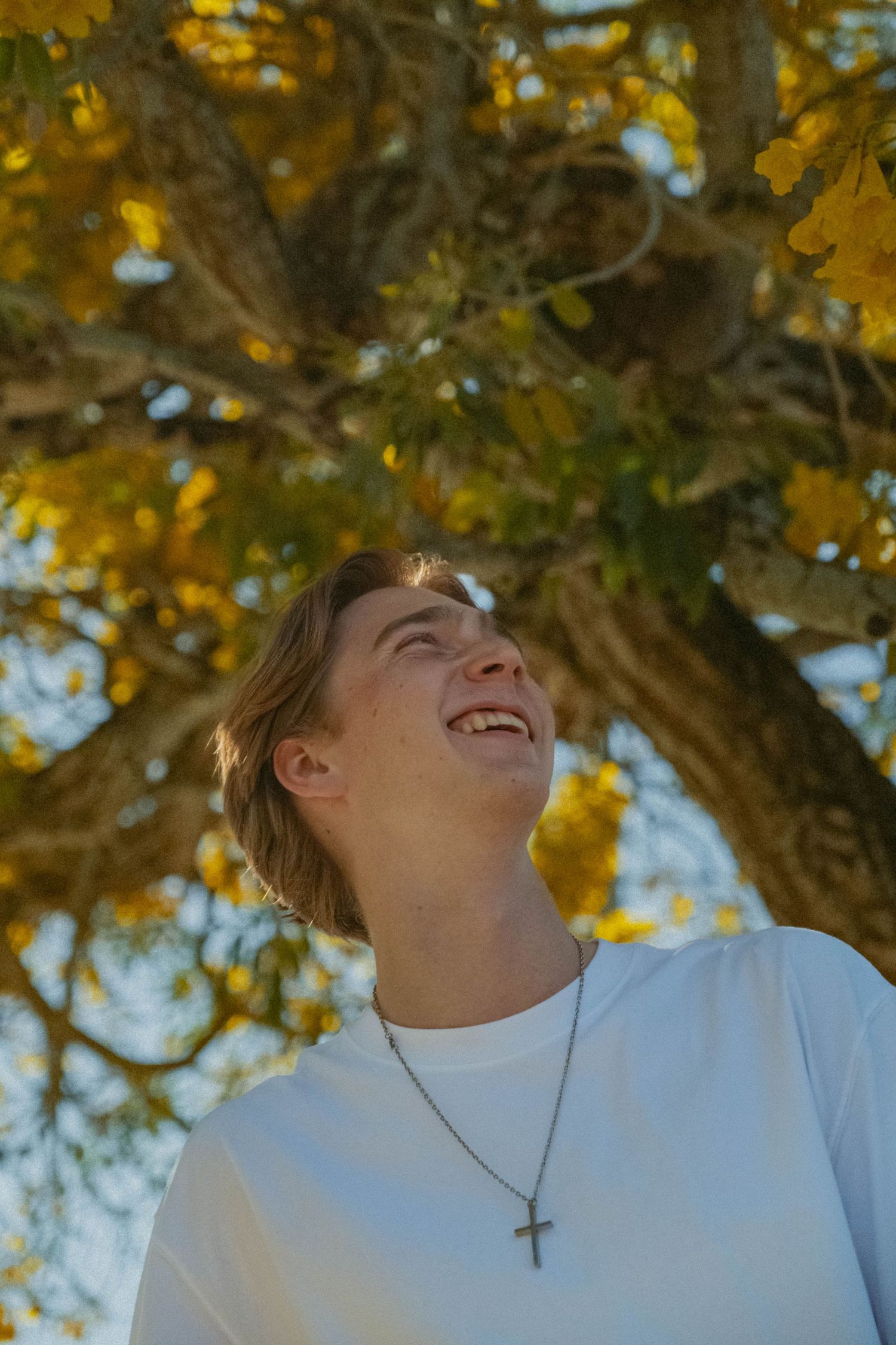 Joyful outdoor portraits under yellow autumn foliage wearing white clothing.