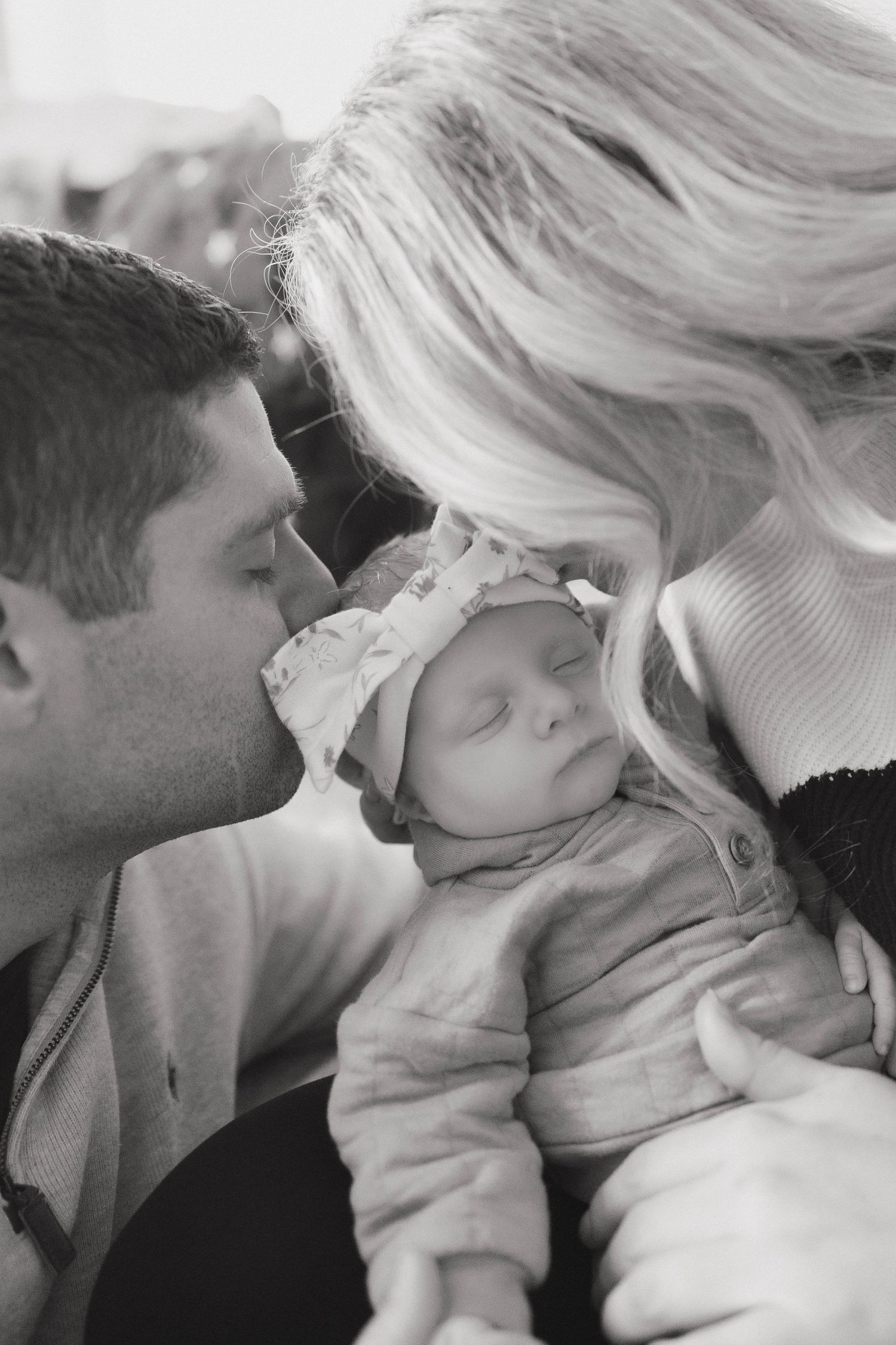 A series of tender black and white photos showing parents sharing sweet moments with their sleeping baby.