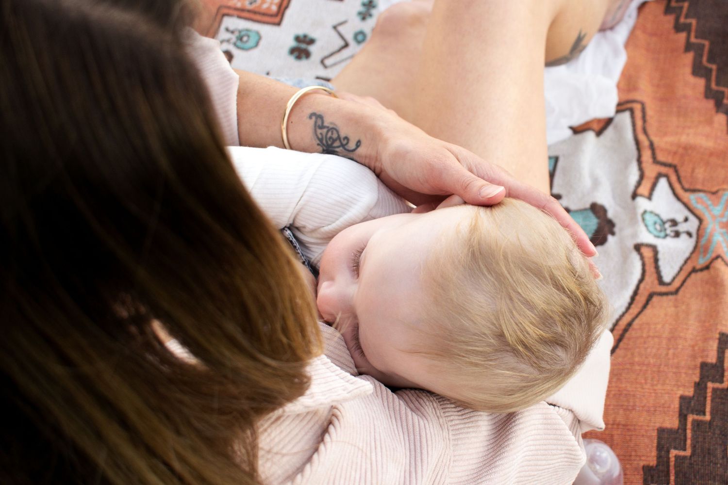 mother holding her baby close as she breastfeeds at a motherhood breastfeeding milestone photoshoot in Maitland NSW
