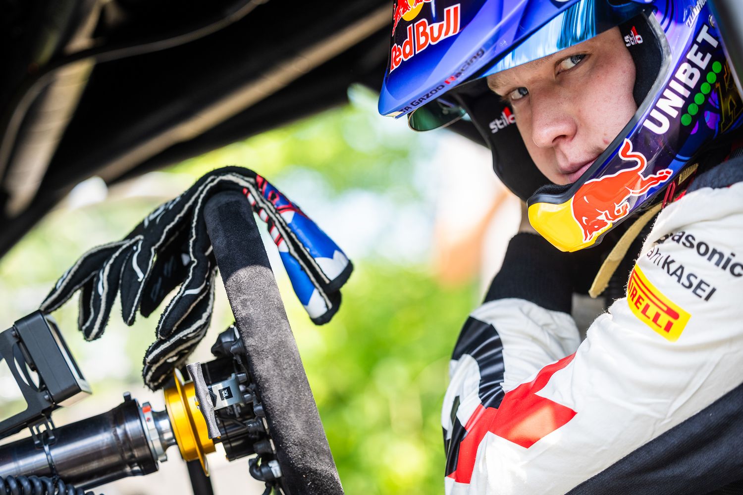 A close-up view of a motorcycle rider's gloved hand gripping the handlebar controls during a race.
