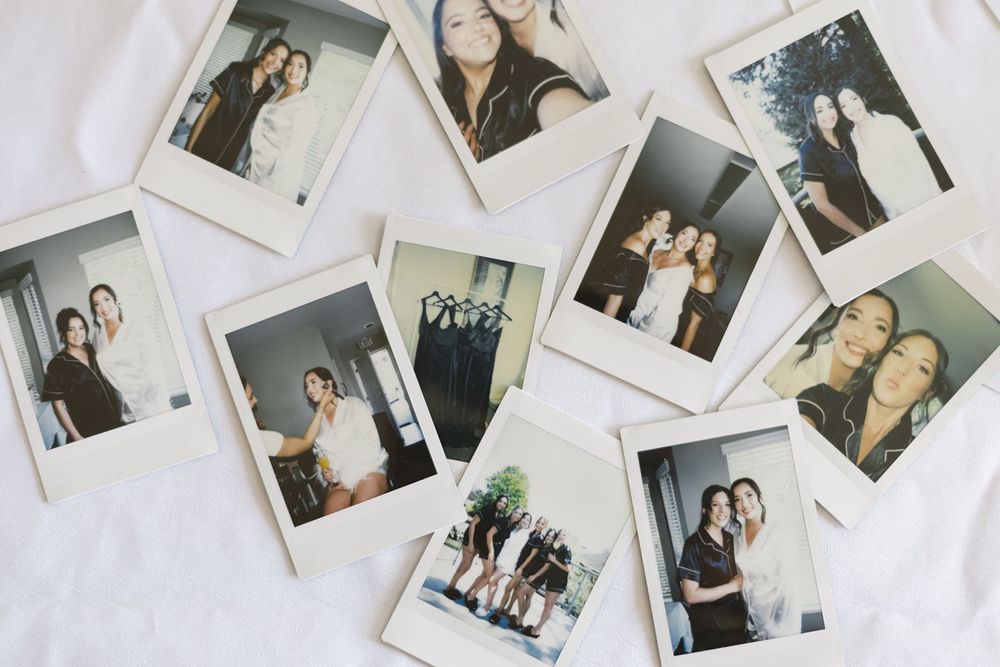 Collection of Polaroid photos scattered on white surface.