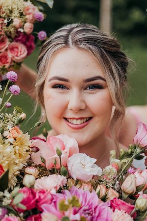 Close-up portrait with pink and peach flowers creating a romantic spring garden atmosphere.