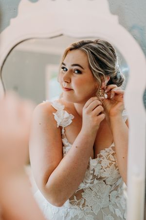 Close-up shots of a bride getting ready for her wedding, showing delicate lace details and jewelry.