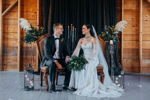 Rustic wooden barn venue decorated for an elegant wedding ceremony with guests seated.