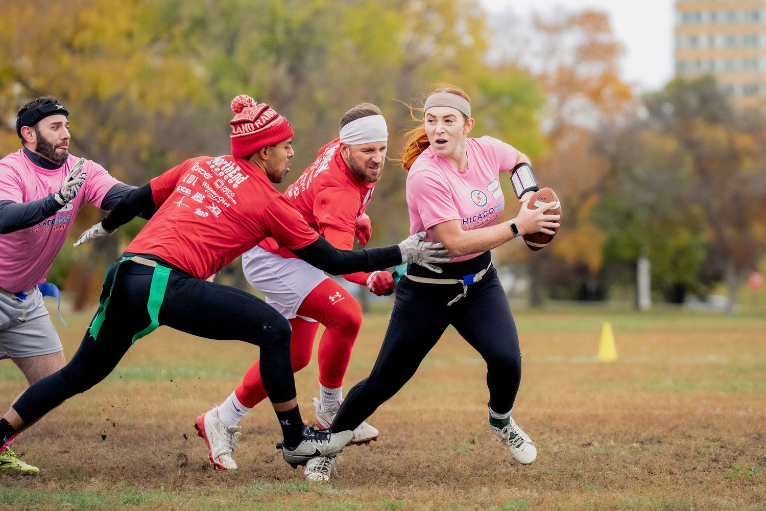 A quarterback attempts to dodge a sack from two rushers
