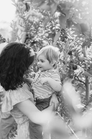 Intimate black and white captures of tender family moments in an apple orchard.