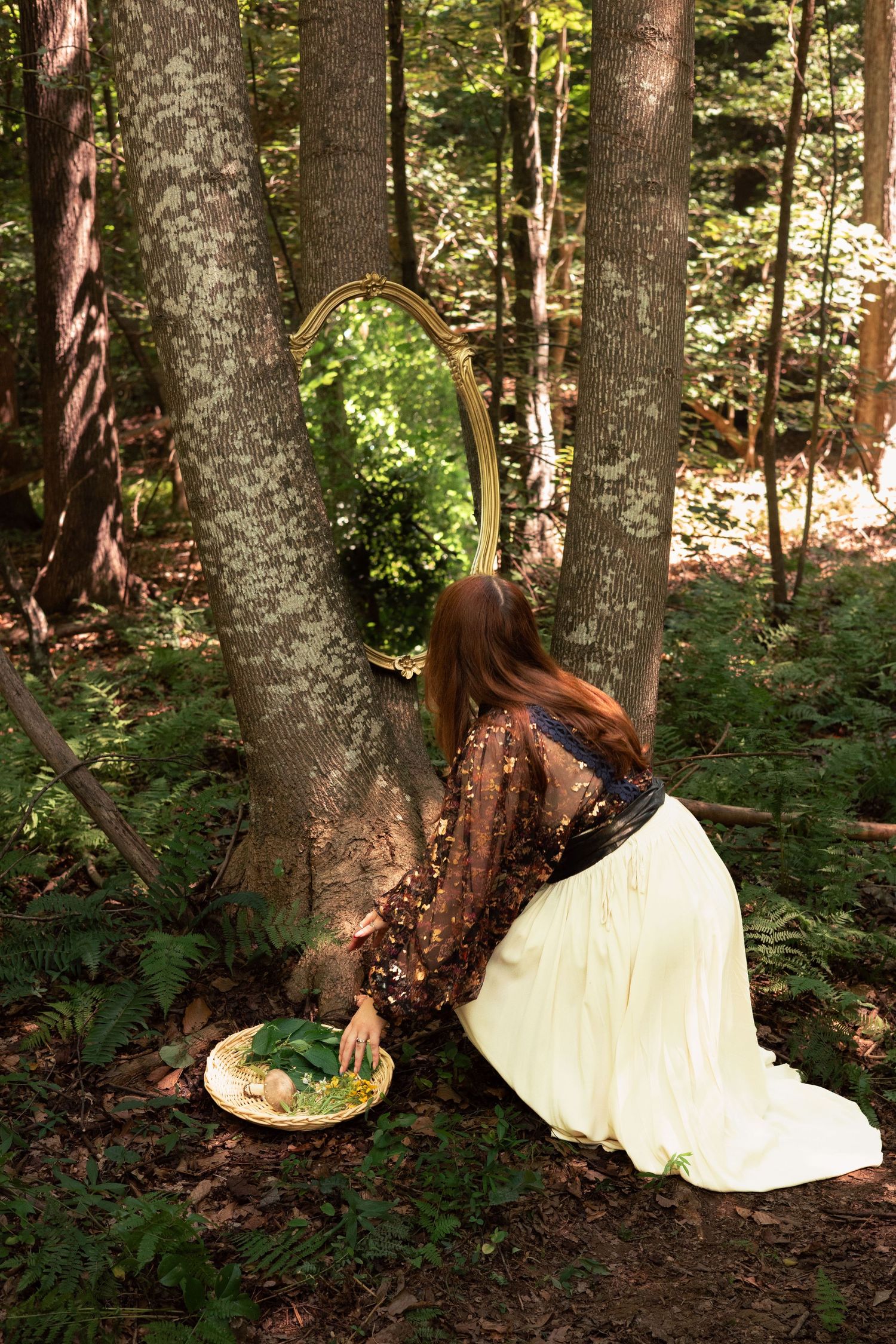 A little girl in a green chiffon dress dances among the giant mushrooms.
