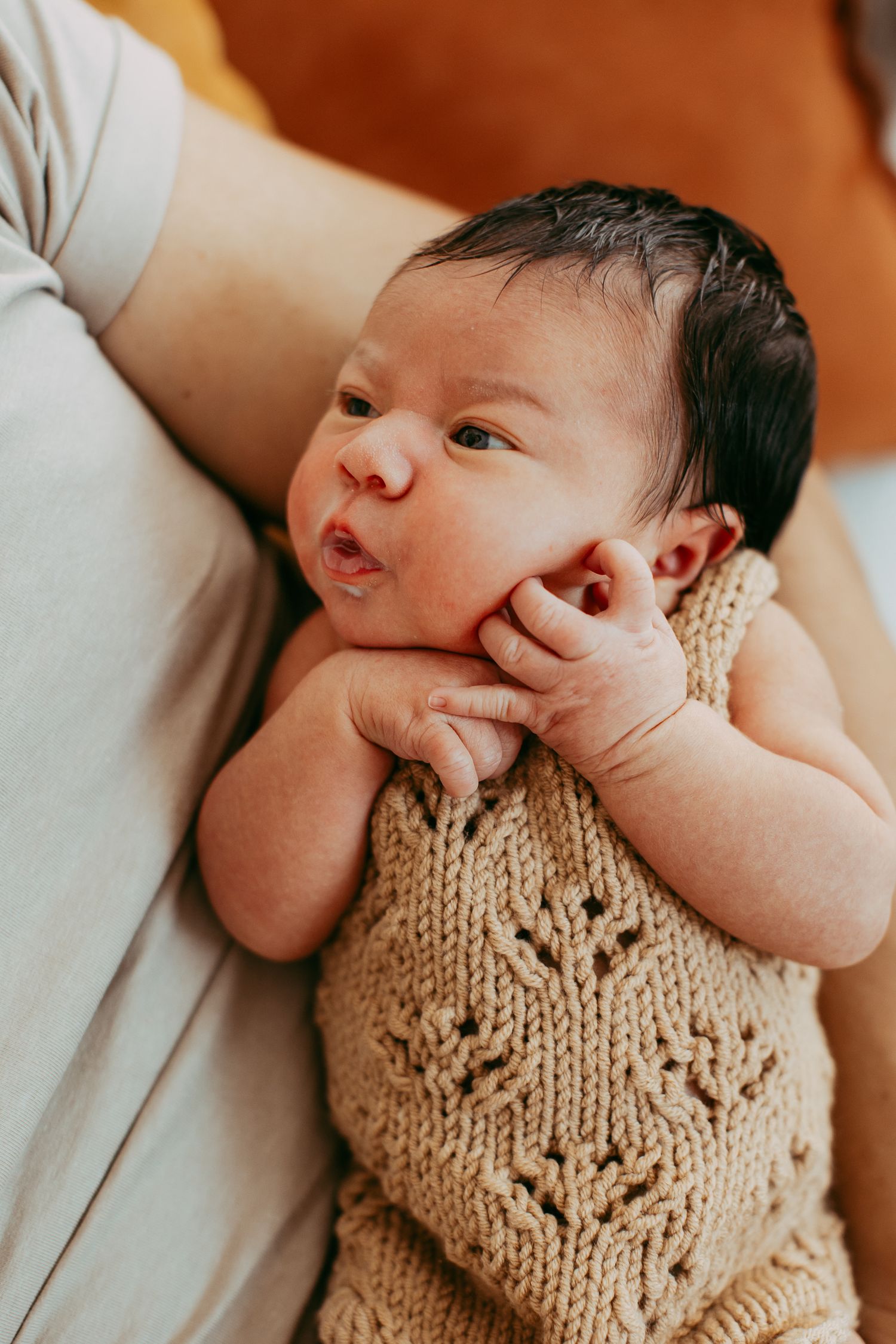 Infant wearing handknit cream colored bib in close-up portrait.
